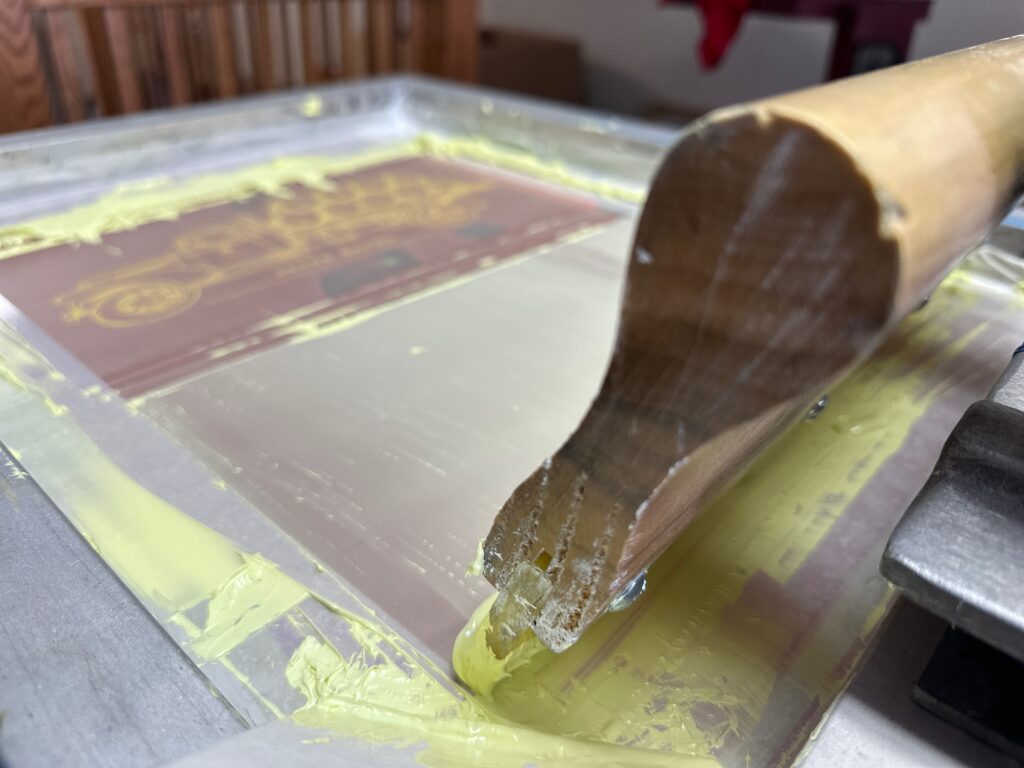 Squeegee on a screen at the Print Plug screen printing shop in Nampa