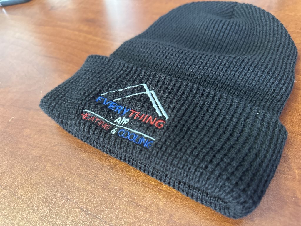 Custom logo embroidery done on a black knit beanie for a local heating and air conditioning service company