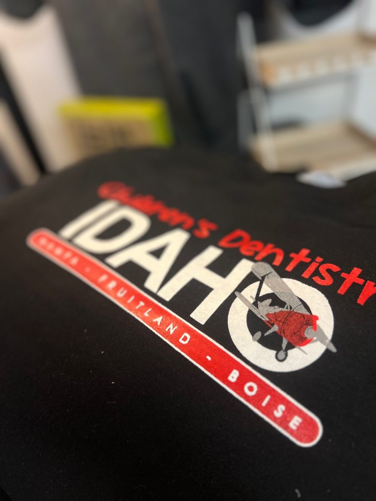 Customized screen printed shirts with company logo on the front at The Print Plug in Nampa